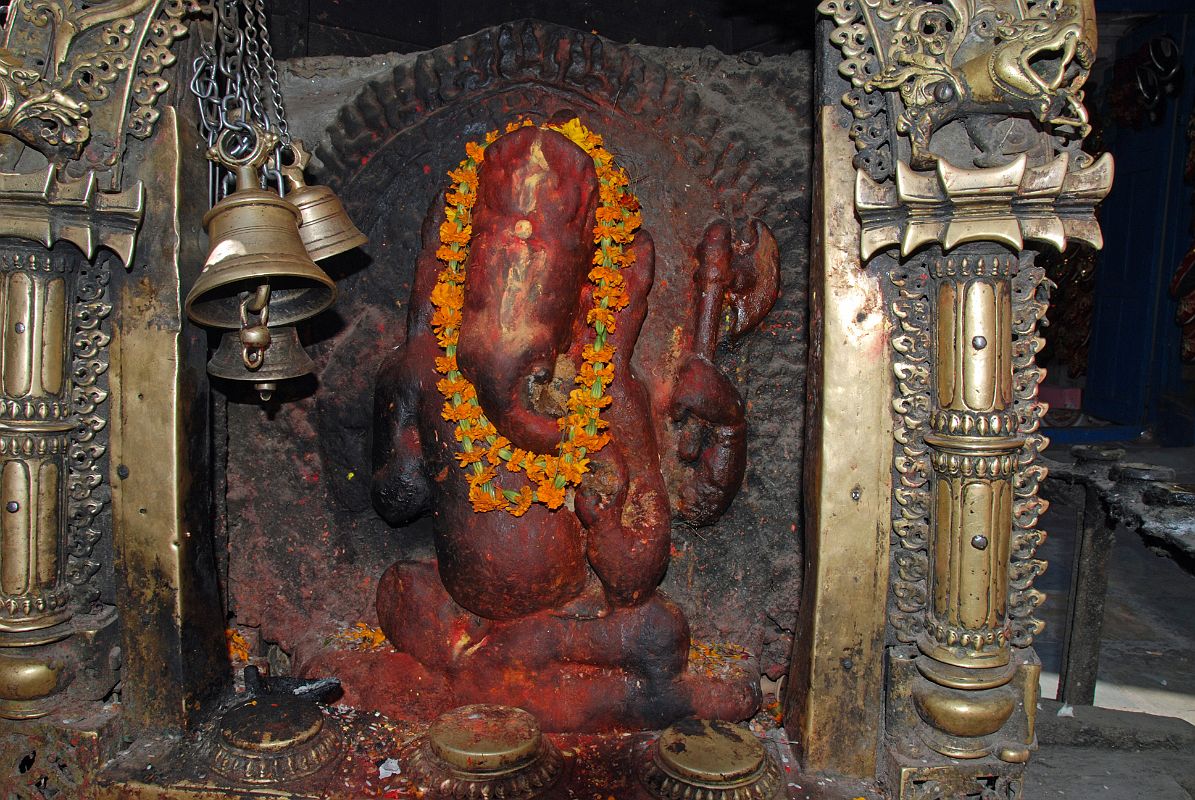 Kathmandu 05 02-3 Indra Chowk Small Ganesh Shrine A bright orange colourful brass statue of Ganesh is much visited in a small niche in Indra Chowk in Kathmandu.